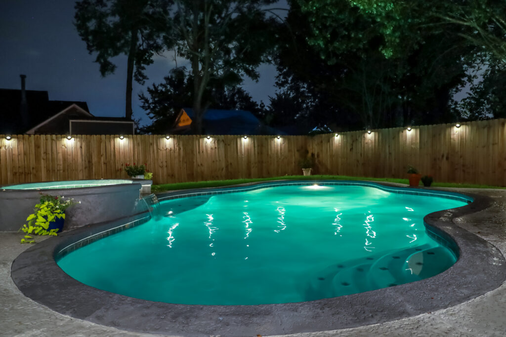 A backyard swimming pool with new lighting installed.