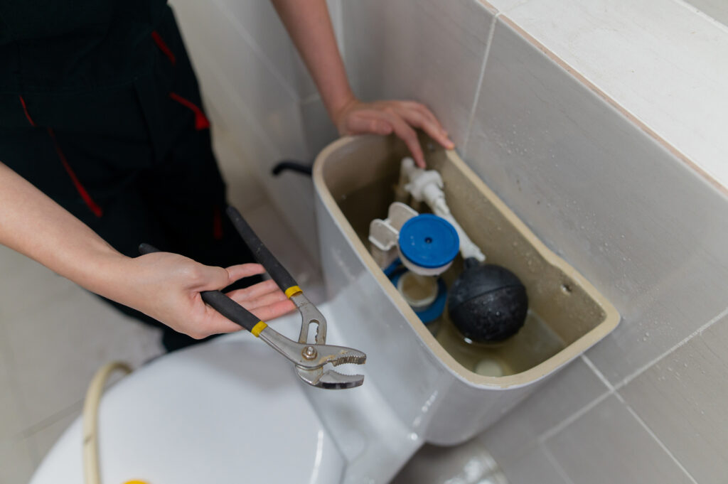 close up hand with tools check and repair water closet